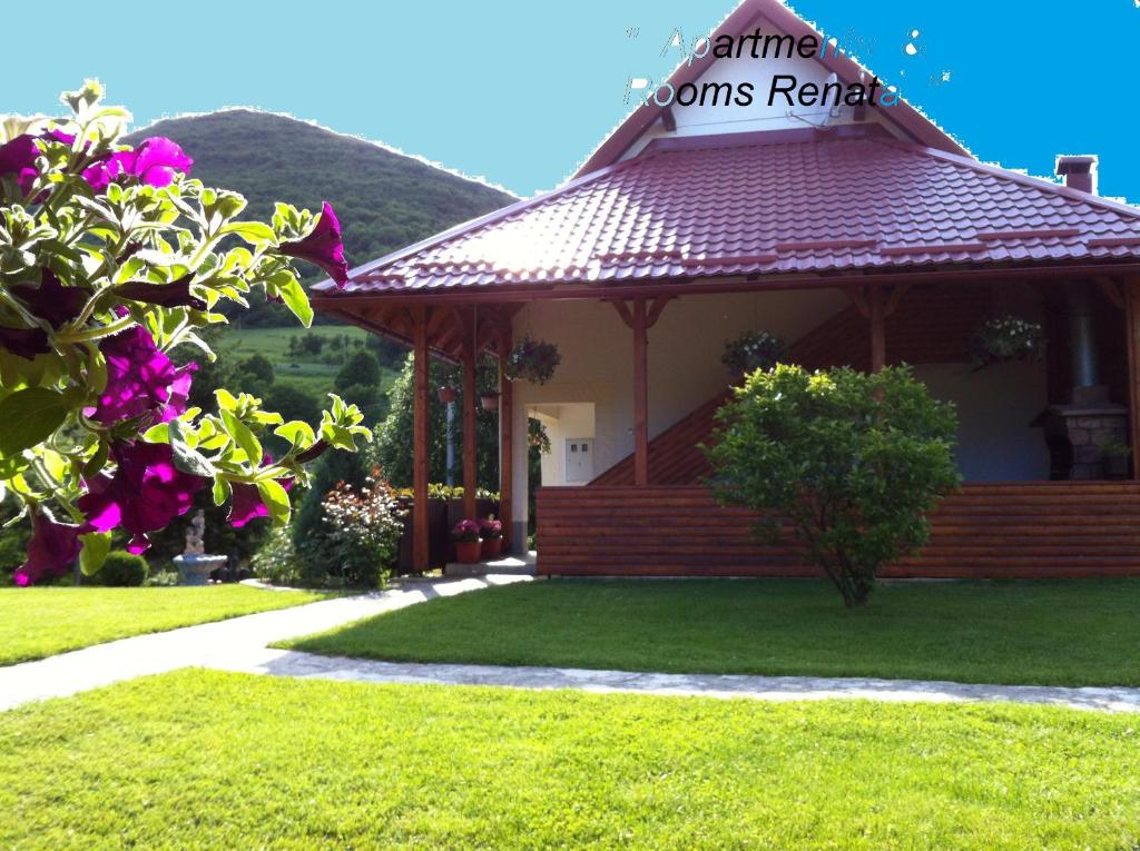 a gazebo with a red roof in a yard at Apartments Renata in Smoljanac