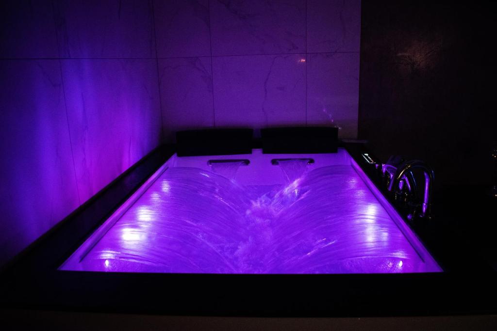 a purple tub with two chairs in a room at Dreamspa in Audincourt