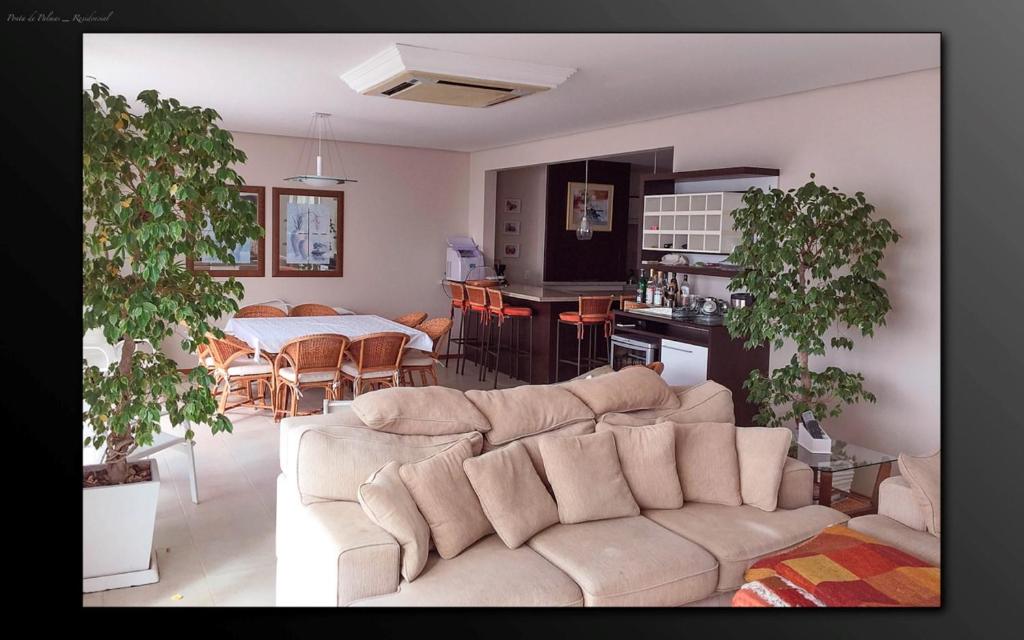 a living room with a couch and a kitchen with a table at Cobertura Praia de Palmas in Governador Celso Ramos