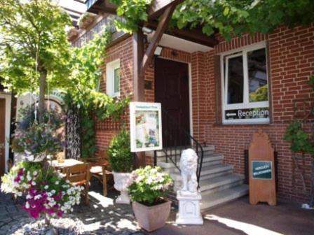 a brick house with stairs and flowers in front of it at Landgasthaus Bonn in Baunatal