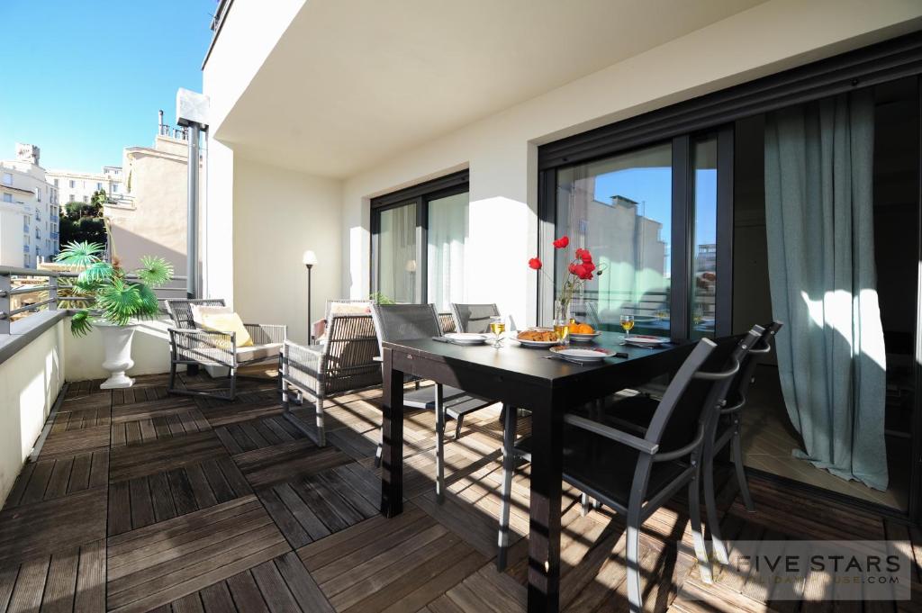 einen Balkon mit einem Tisch und Stühlen in der Unterkunft Suite Relax Five Stars Holiday House in Nizza