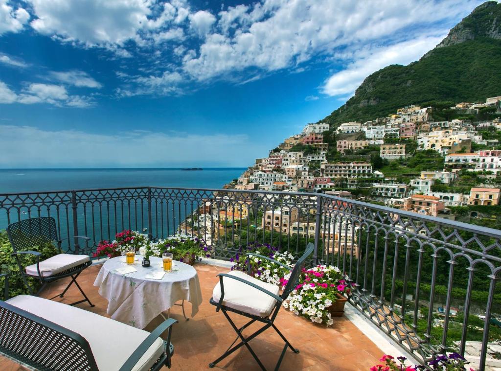 a balcony with a table and chairs and a view of a city at Palazzo Margherita in Positano