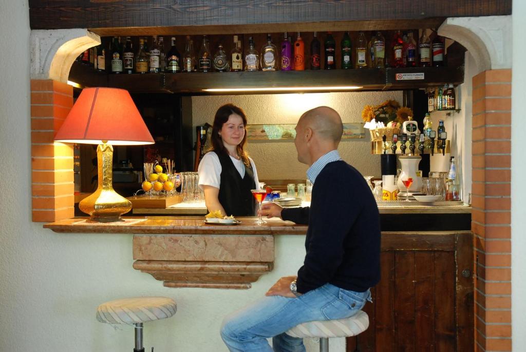 a man and a woman sitting at a bar at Hotel Valdor in Cavallino-Treporti