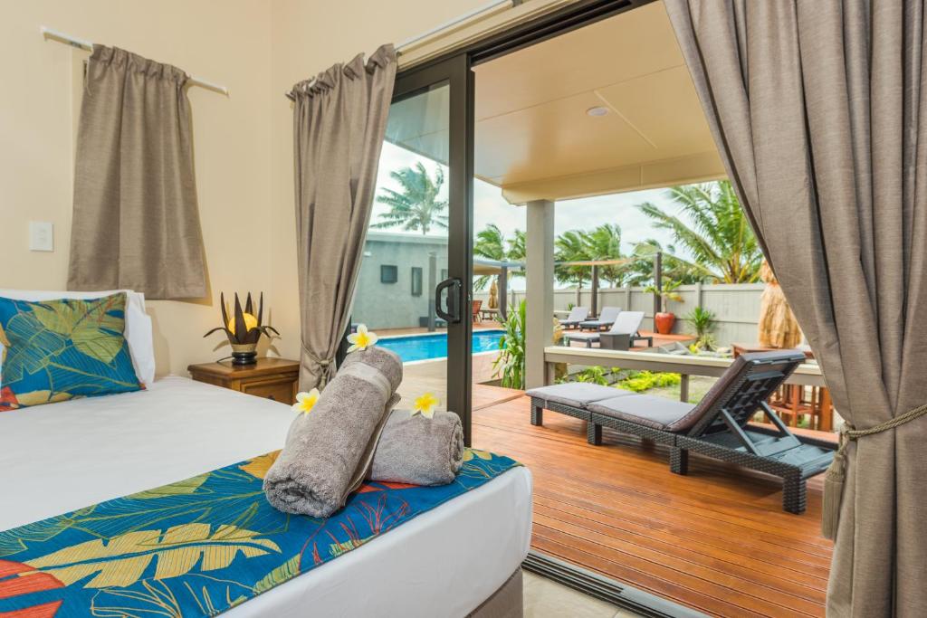 a bedroom with a bed and a balcony at Cook Islands Holiday Villas - Turangi Lagoon in Muri