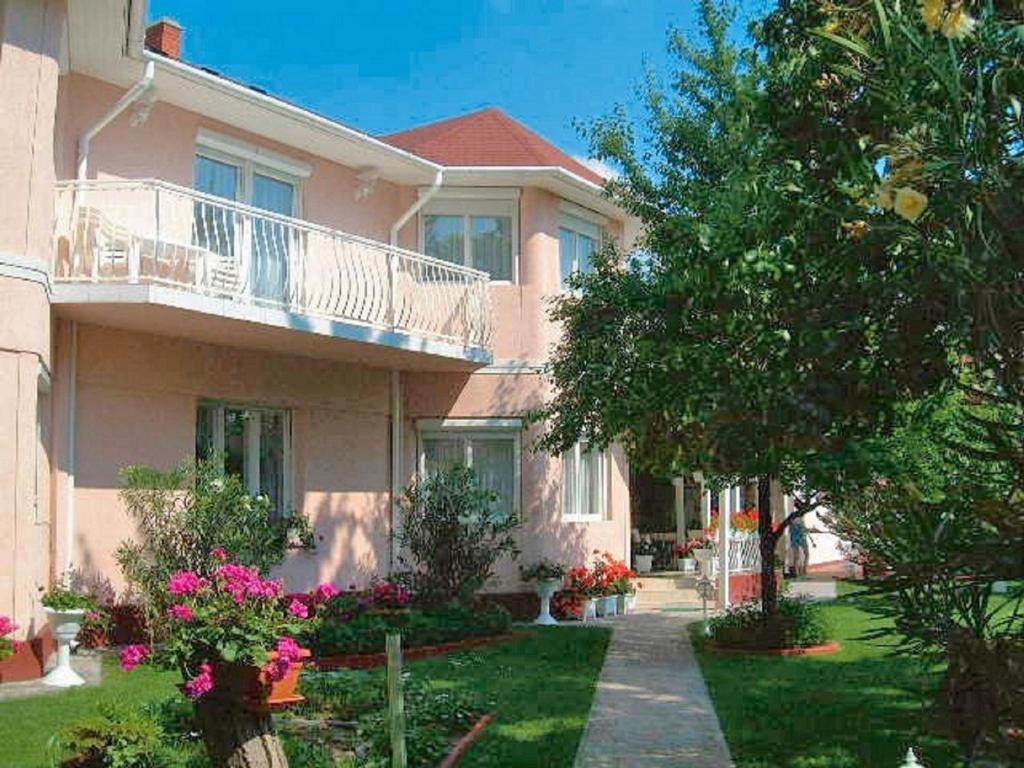 een groot roze huis met een balkon en bloemen bij Apartment Siofok, Lake Balaton 4 in Siófok