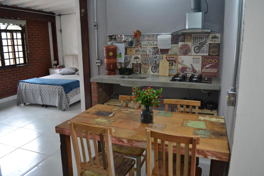 1 dormitorio y cocina con mesa y sillas. en Studio House Loft, en São Paulo