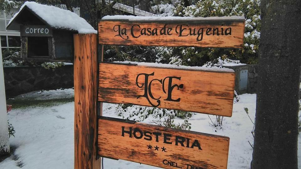 una señal en la nieve junto a un árbol en Hostería La Casa de Eugenia en San Martín de los Andes