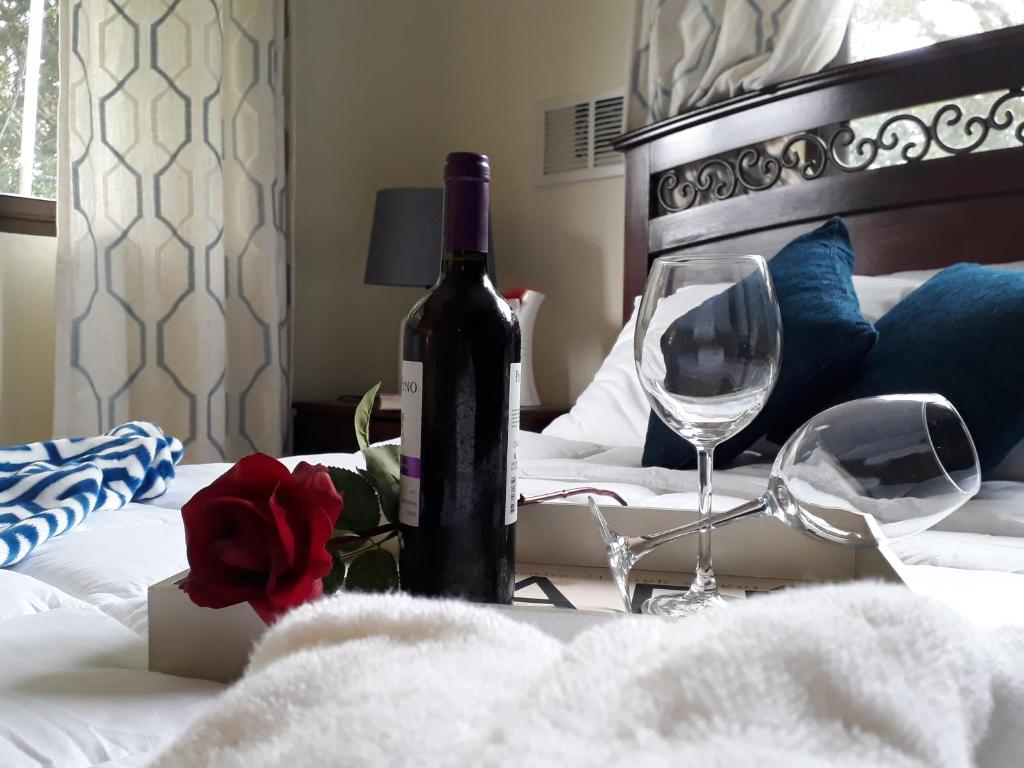 een fles wijn en twee glazen op een bed bij Casa Mirango Boquete in Boquete