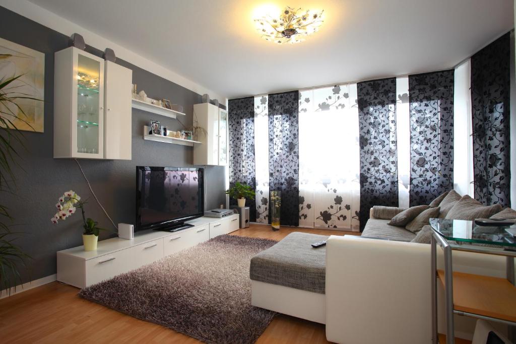 a living room with a white couch and a tv at Private Apartments Hannover - Room Agency in Hannover