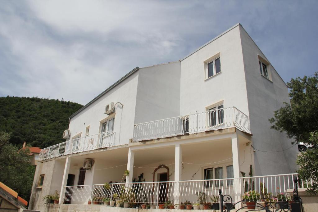 a large white building with balconies on it at Bjelopera Rooms in Zaton