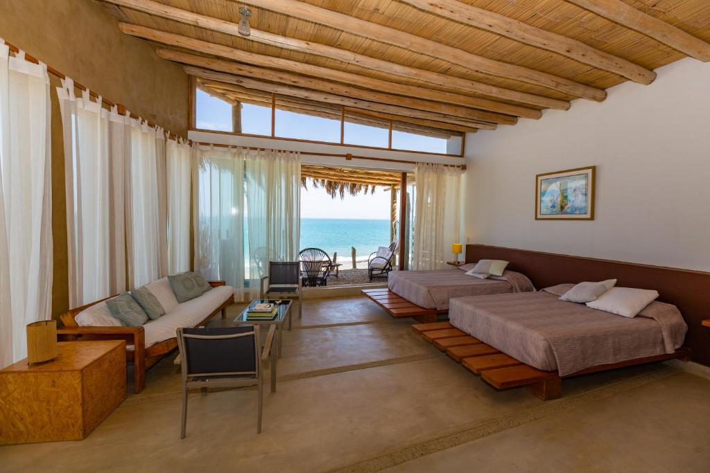 ein Schlafzimmer mit 2 Betten und ein Wohnzimmer mit Meerblick in der Unterkunft Pirámide Títi in Los Órganos