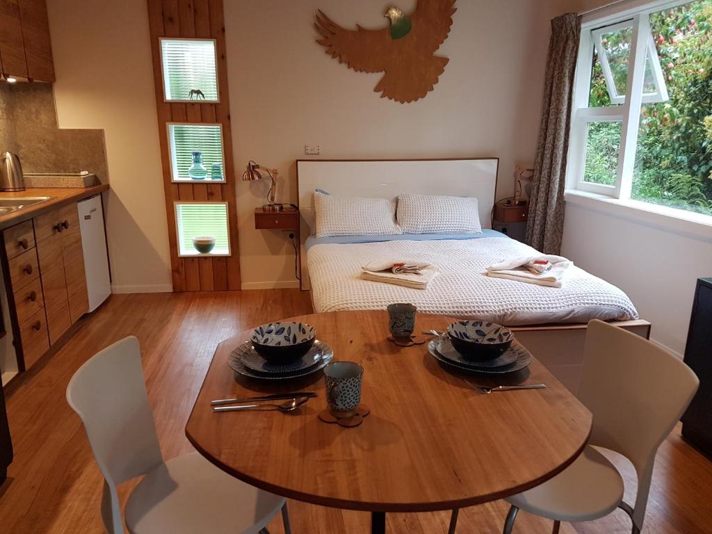 a dining room with a table and a bed at Chalet Karaka in Takaka