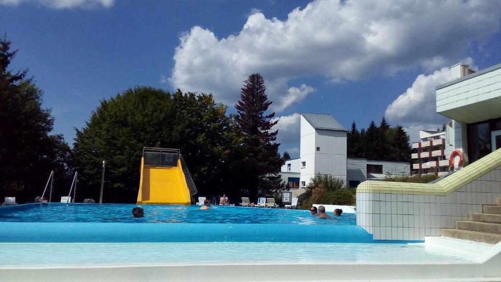 uma grande piscina com um escorrega na água em 2 Raum Ferienwohnung Sonnenschein em Sankt Englmar