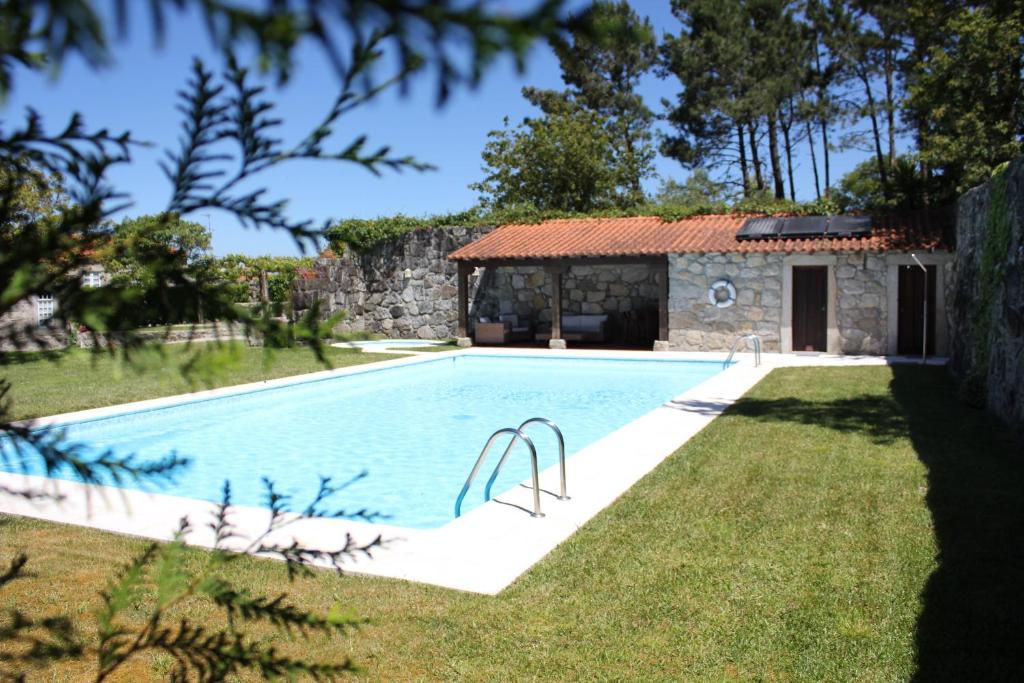 a swimming pool in a yard next to a building at Casa do Nato -Turismo Rural in Viana do Castelo