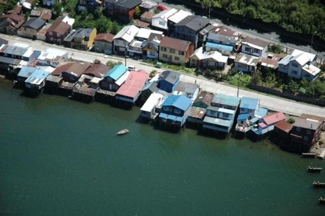 an aerial view of a group of houses in the water at Palafito Azul Apart Hotel in Castro