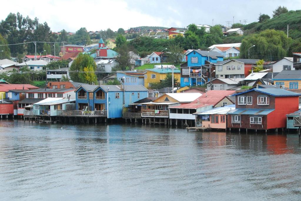a group of houses next to a body of water at Palafito Azul Apart Hotel in Castro