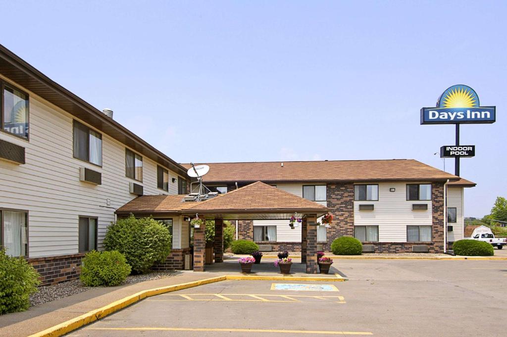 ein Hotel mit einem Schild vor einem Parkplatz in der Unterkunft Days Inn & Suites by Wyndham Davenport East in Davenport