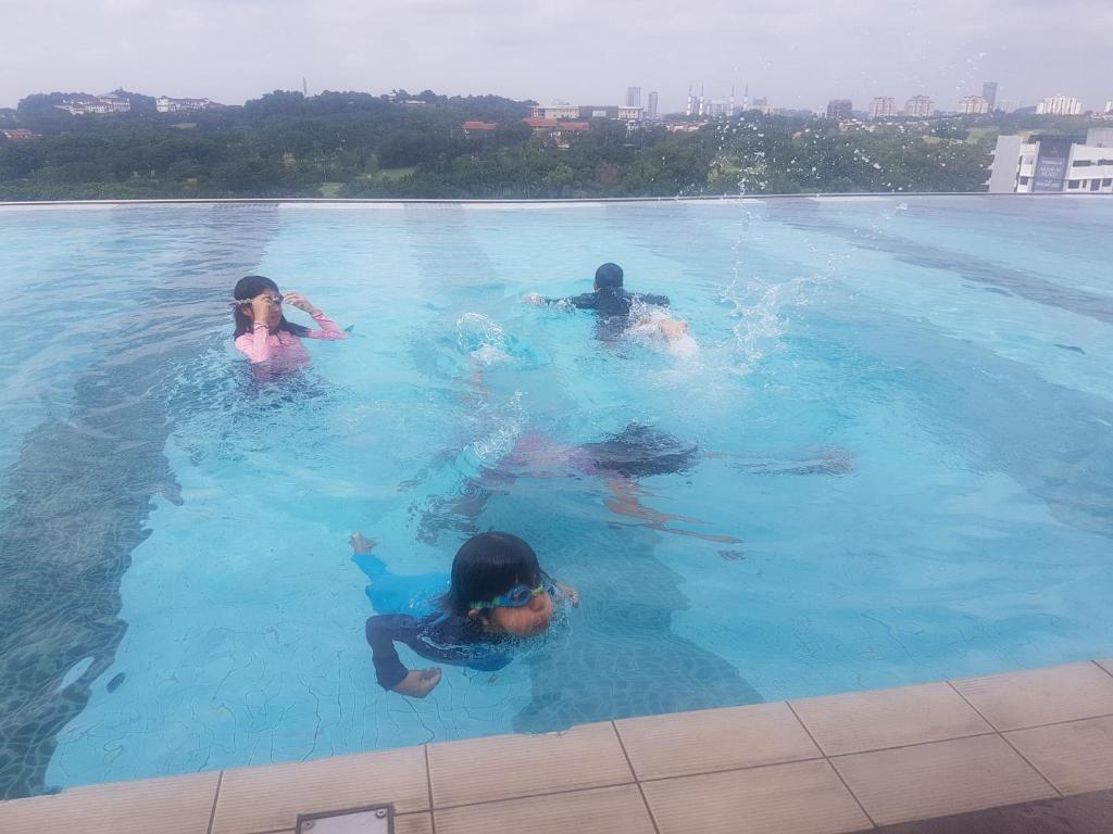 three children are swimming in a swimming pool at Suria Jelutong in Shah Alam