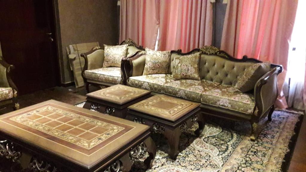 a living room with a couch and two tables at royal cottage guest house in Islamabad