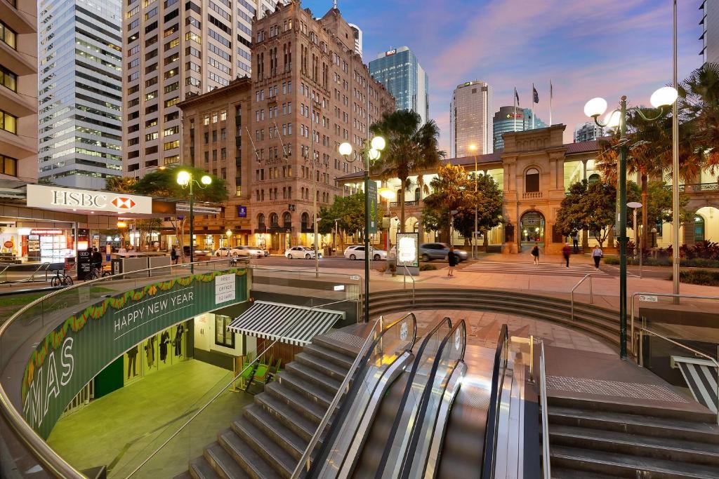 a set of escalators in a city with buildings at Manor Apartment Hotel in Brisbane