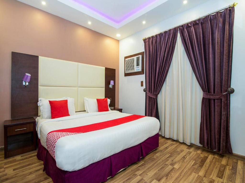 Cette chambre comprend un grand lit avec des oreillers rouges. dans l'établissement Yahalla Hotel Units, à Djeddah