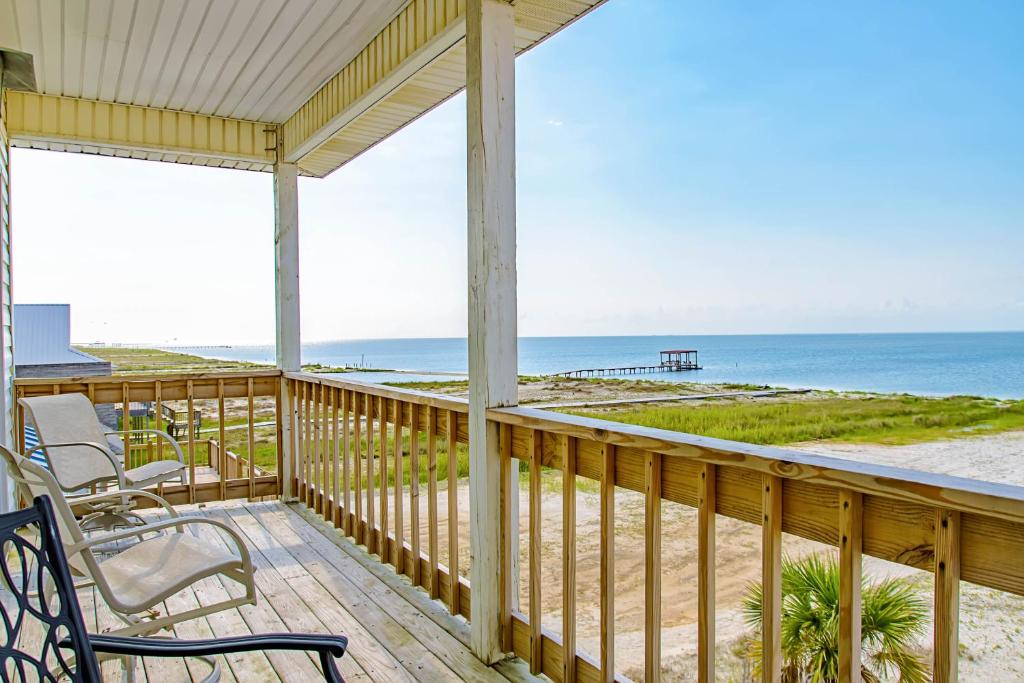 a porch with chairs and a view of the beach at Surf N' Turf in Dauphin Island