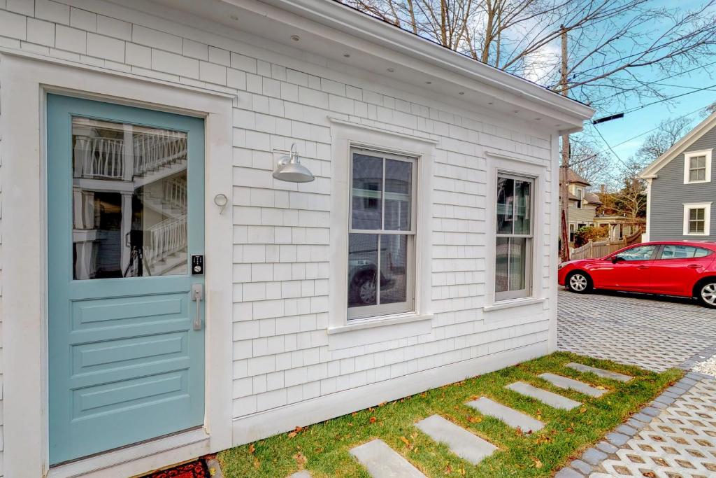 una casa blanca con una puerta azul y un coche rojo en Provincetown Paradise, en Provincetown