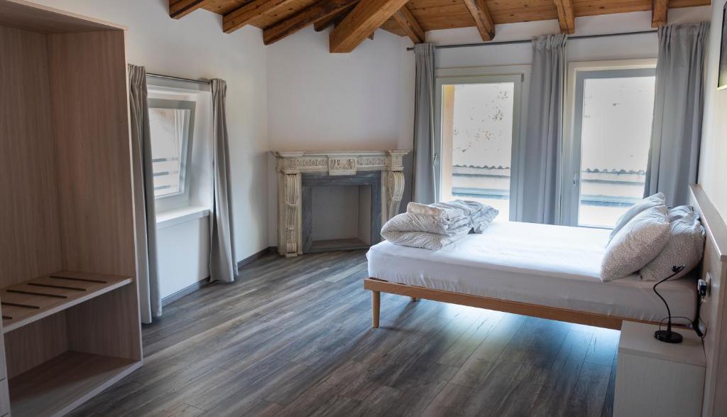 een slaapkamer met een bed en 2 ramen bij TrentoApartment in Trento