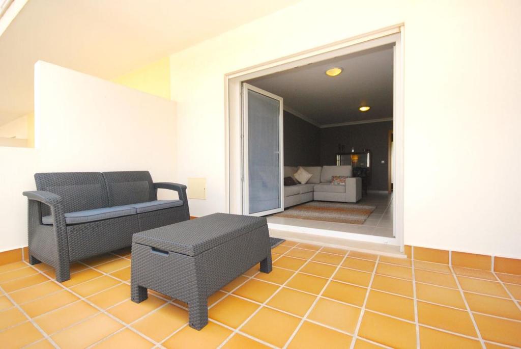 a living room with a couch and a chair at Marta Apartment - Balcony, Patio, Pool in Ferrel