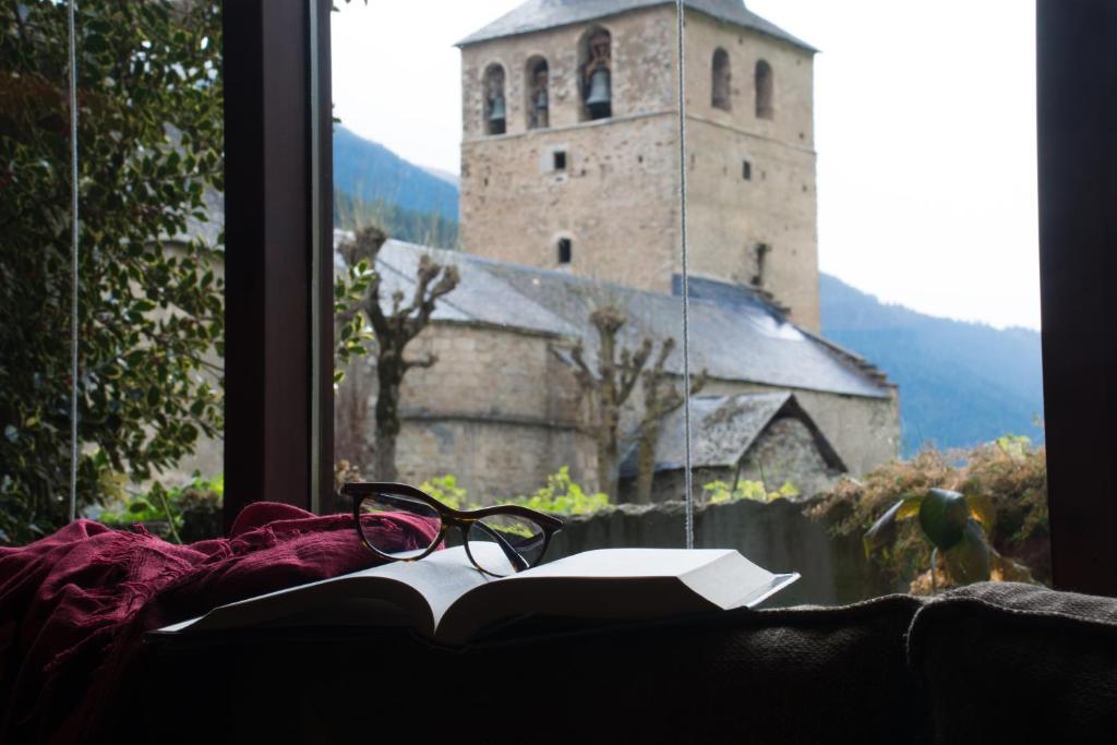 un par de gafas sentadas en un libro delante de una ventana en Garos Ostau, en Garós