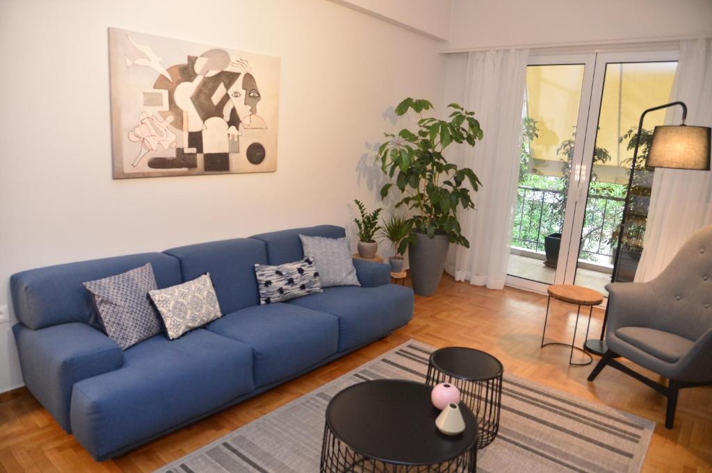 ein Wohnzimmer mit einem blauen Sofa und einem Tisch in der Unterkunft Athens Destination: a home away from home in Athen