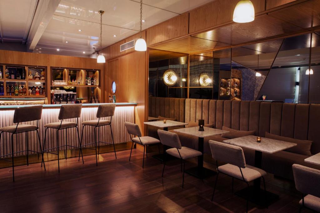 a restaurant with tables and chairs and a bar at Dar El Marsa Hotel & Spa in La Marsa