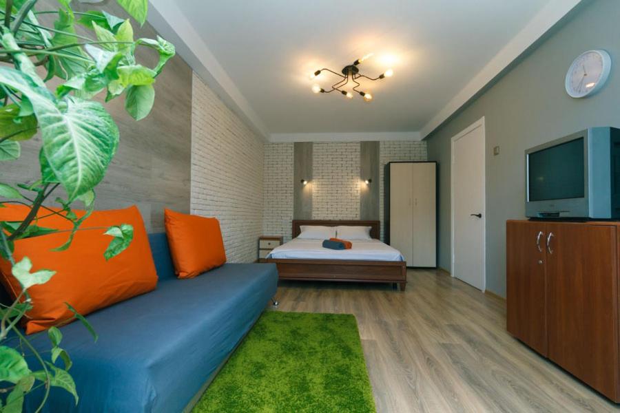 een woonkamer met een blauwe bank en een bed bij Apartment near Dream Town in Kiev
