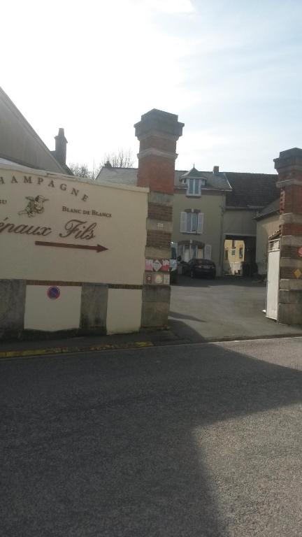 un bâtiment avec un panneau sur le côté d'une rue dans l'établissement VILLA.H GARDEN, à Cramant