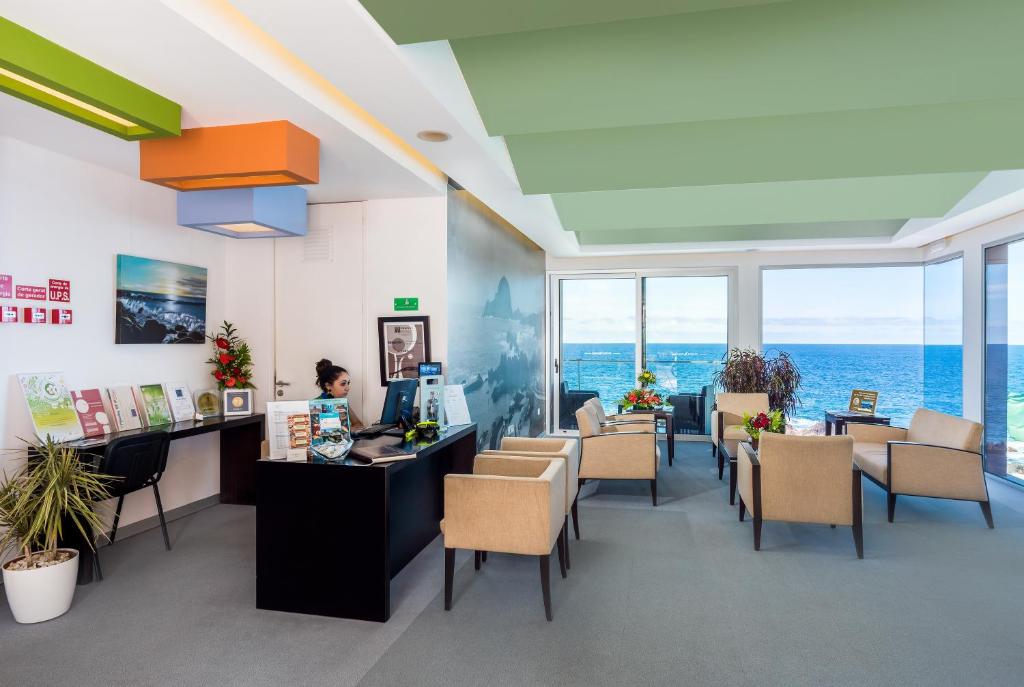 an office with chairs and a woman sitting at a desk at Aqua Natura Madeira in Porto Moniz