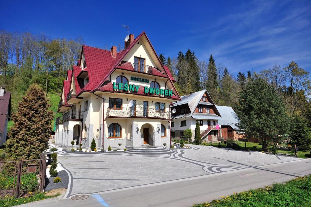 um grande edifício com um telhado vermelho numa rua em Leśny Dworek em Biały Dunajec