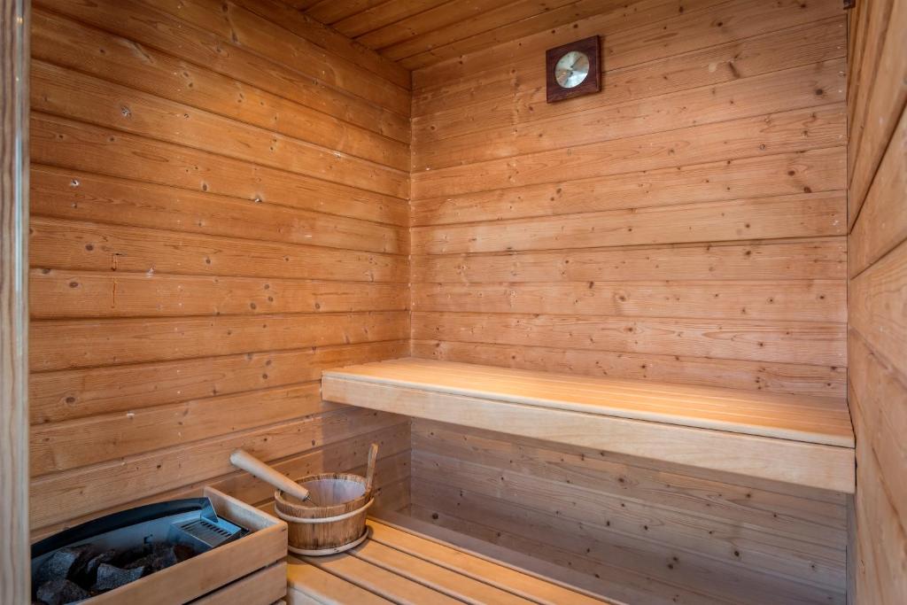 a wooden sauna with a bench and a clock at Aqua Natura Madeira in Porto Moniz