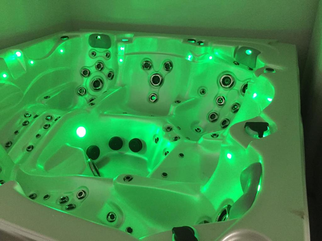 une baignoire en verre vert éclairée dans l'établissement Aparthotel Des 2 Caps, à Ambleteuse
