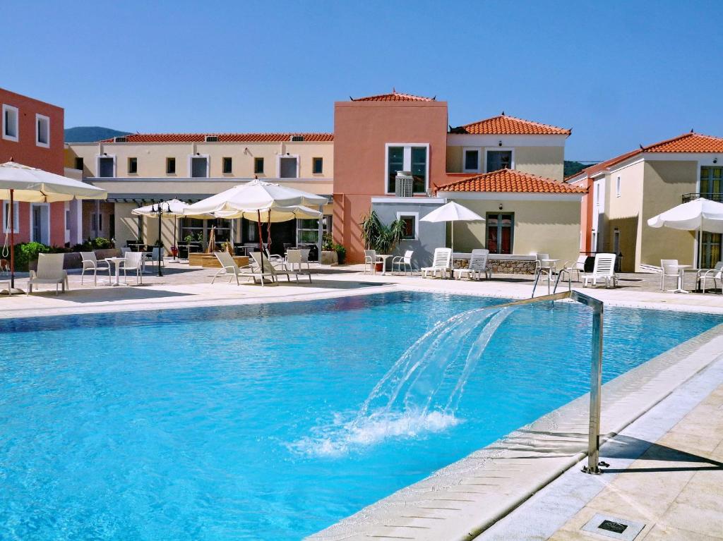 una piscina con sedie e ombrelloni in un resort di Theofilos Hotel Petra a Pétra