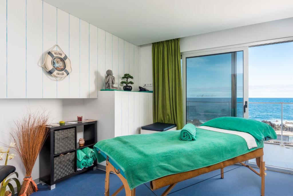 a bedroom with a bed with a view of the ocean at Aqua Natura Madeira in Porto Moniz