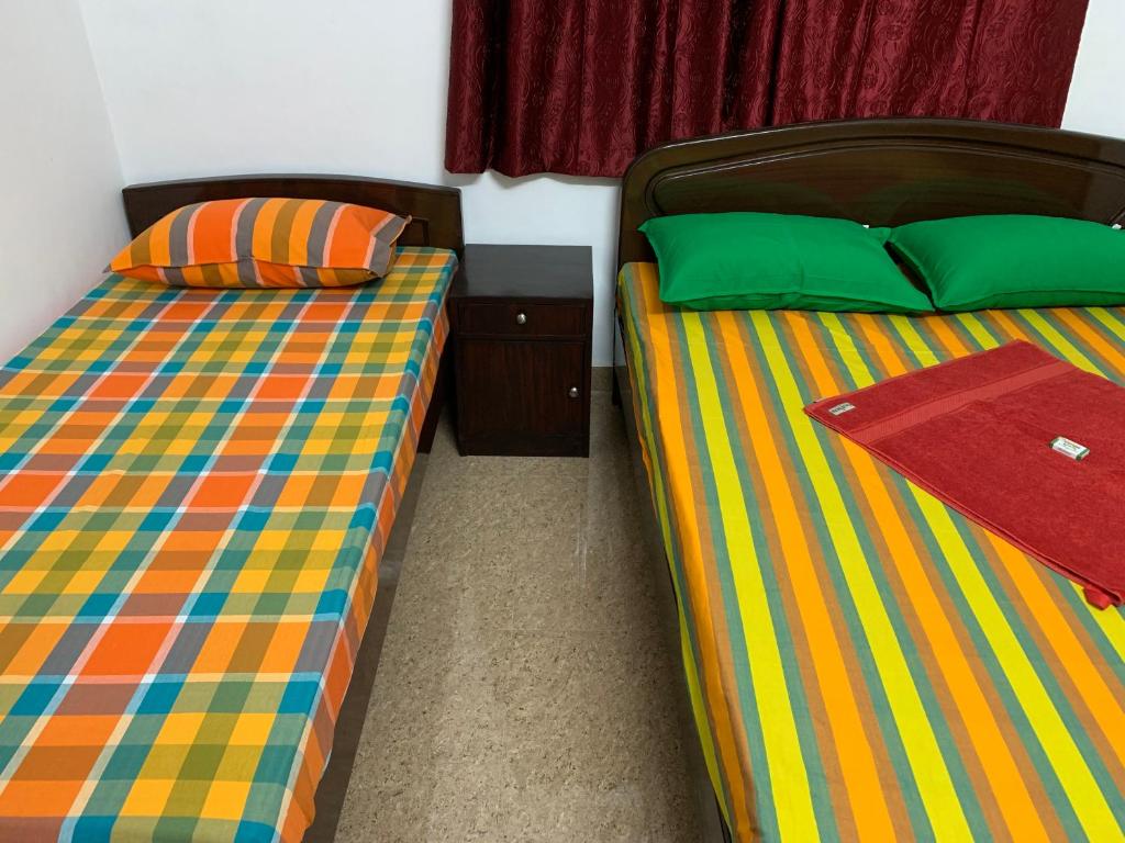duas camas sentadas uma ao lado da outra num quarto em TEMPLE TREE Next to Apollo & SANKARA NETHRALAYA HOSPITALS em Chennai