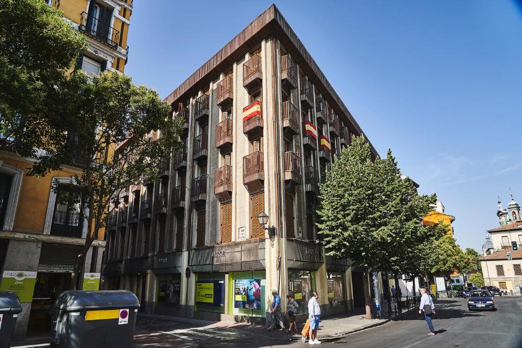 um edifício numa rua com pessoas a andar na frente dele em Apartamentos Cava Baja em Madrid