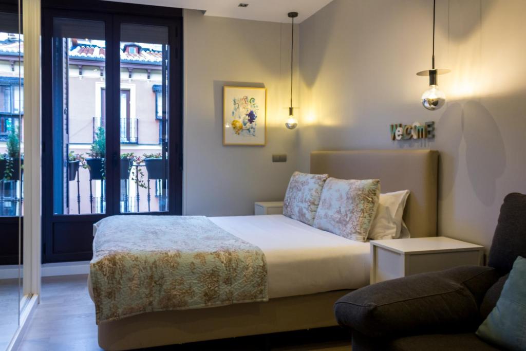 マドリードにあるArenal Suites Preciadosのベッドルーム1室(ベッド1台、ソファ、窓付)