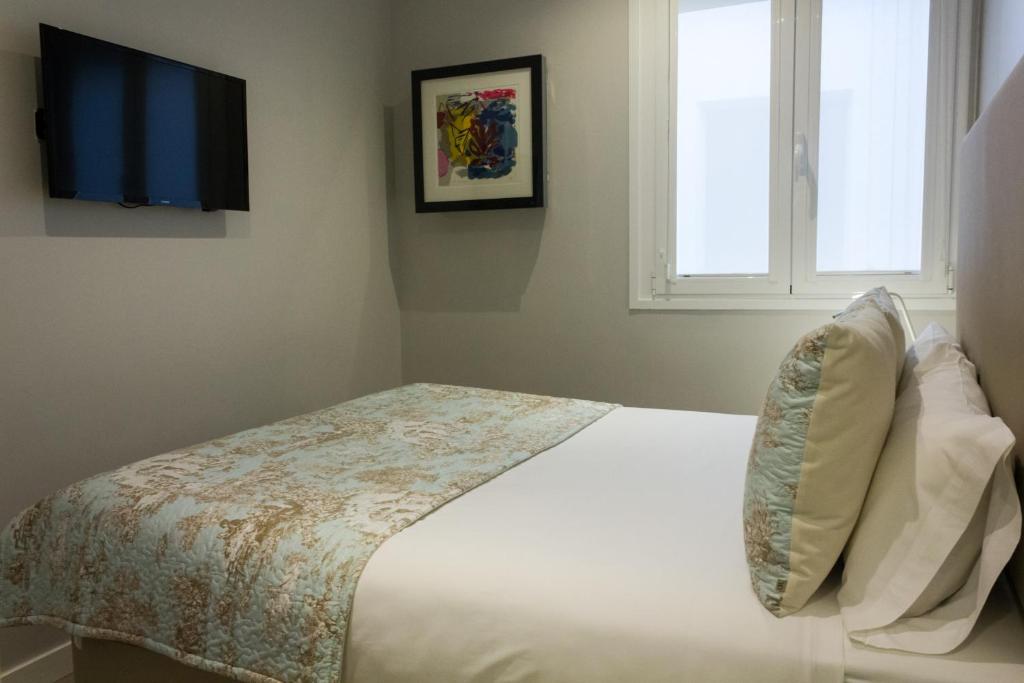 A bed or beds in a room at Arenal Suites Preciados
