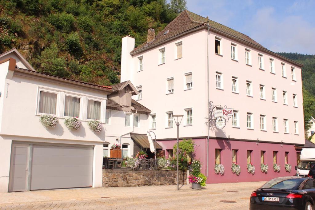 um grande edifício branco com um carro estacionado em frente em Gasthof Rose em Hornberg