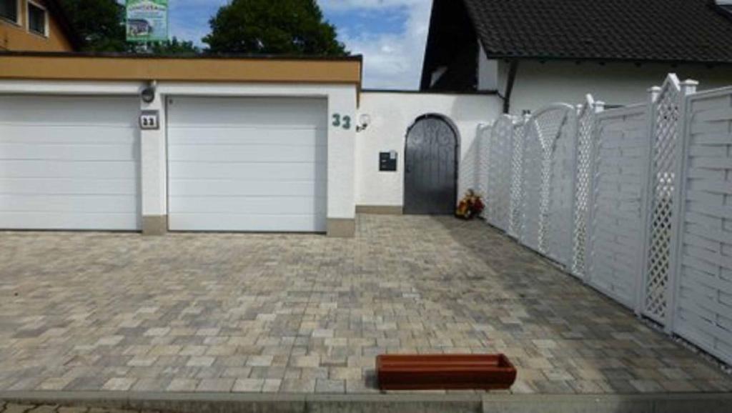 a driveway with two garage doors and a fence at Gästehaus Diemer in Margetshöchheim