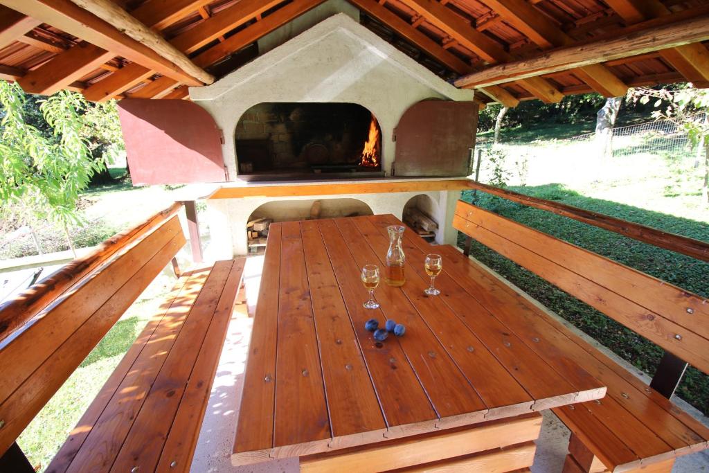 an outdoor table with wine glasses and a fireplace at House Marko Breze in Ledenice