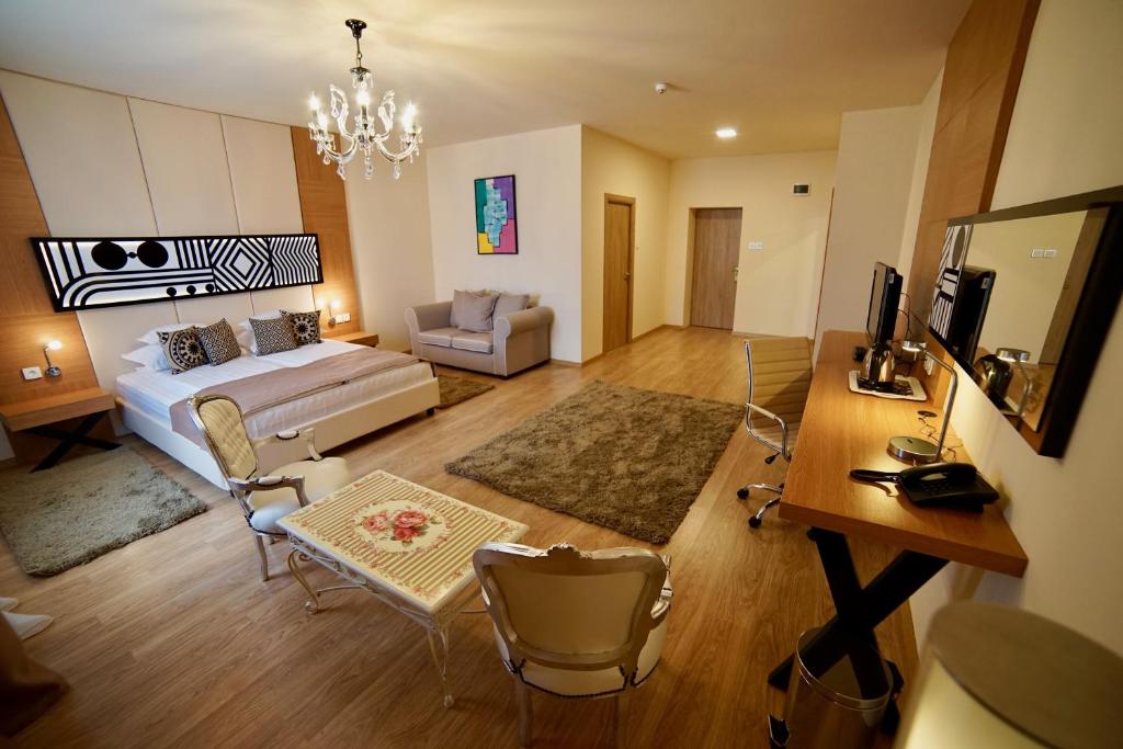 una sala de estar con cama y escritorio y una habitación en Hotel Astoria, en Hunedoara