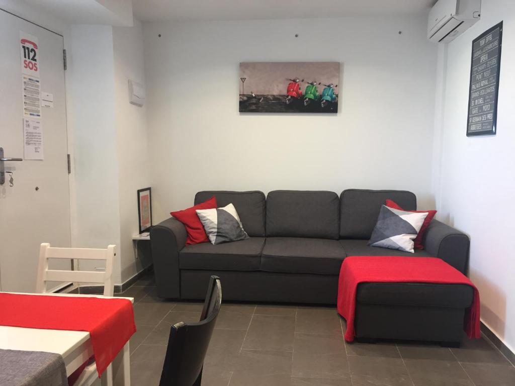 uma sala de estar com um sofá e um repousa-pés vermelhos em Apartamento Plaza De Toros Centro em Alicante