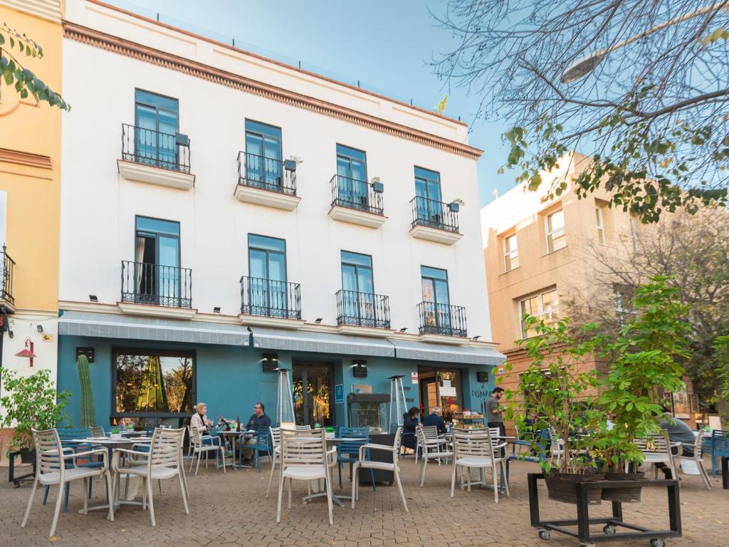 a large building with tables and chairs in front of it at The Corner House in Seville